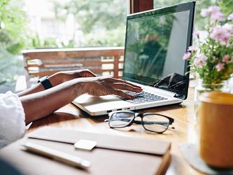 businesswoman's hands working on laptop at desk